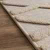 A close-up view of a beige rug with a geometric pattern, placed on a wooden floor. Anteprima dell’immagine prodotto