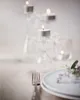 A table setting with tea lights in glass holders, a fork, and a plate. Podgląd zdjęcia produktu