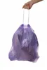 A hand holding a full purple trash bag by its drawstring. Náhled obrázku produktu
