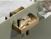A modern bathroom sink with a gold finish and black faucet, reflected in a mirror. Produktbild-Vorschau