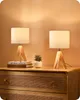 Two bedside lamps with wooden bases are placed on a wooden dresser. Produktbild-Vorschau