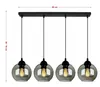 A black linear chandelier with four smoked glass globe shades, suspended from a black rectangular ceiling plate. Produktbild-Vorschau