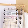 Multiple hangers with pants are displayed in a closet. Produktbild-Vorschau