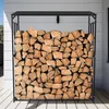 A metal firewood rack filled with logs, placed outdoors against a white wall. Podgląd zdjęcia produktu