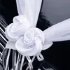 Nahaufnahme einer weißen Organza-Girlande mit zwei dekorativen Rosenblüten auf der Motorhaube eines schwarzen Autos befestigt. Produktbild-Vorschau
