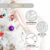 A person decorating a white Christmas tree with ornaments. Produktbild-Vorschau