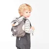 A young child wearing a dog-themed backpack. Produktbild-Vorschau