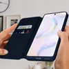 Hands holding a dark blue flip case for a smartphone, with cards inserted into the case. Náhľad obrázku produktu
