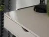 A close-up view of a beige desk with a drawer and a black lamp and a cactus on top. Anteprima dell’immagine prodotto