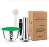 A set of reusable coffee capsules and accessories, including a tamper, scoop, and brush, displayed with their packaging. Produktbild-Vorschau