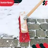 A red broom is sweeping snow off a paved walkway. Náhľad obrázku produktu