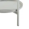 A close-up view of the leg and lower shelf of a light gray metal plant stand. Podgląd zdjęcia produktu