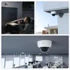 Collage of three images showing a Reolink surveillance camera in different settings: outdoors by a garage, mounted on a building exterior, and indoors in an office. Produktbild-Vorschau