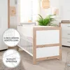 A nursery room setting with a crib and a dresser. Anteprima dell’immagine prodotto