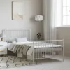 A white metal bed frame with a headboard and footboard, set up in a bedroom with bedding and a rug. Náhled obrázku produktu