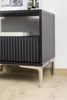 A close-up shot of a modern black cabinet with silver legs. Produktbild-Vorschau