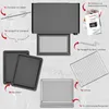 An overhead view of a mini oven and its accessories, laid out on a textured gray surface. Produktbild-Vorschau