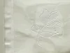 A close-up of white fabric with a subtle embossed floral pattern. Produktbild-Vorschau