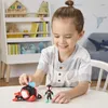 A young boy is playing with a Miles Morales action figure and a vehicle on a table. A bookshelf with toys and books is in the background. Anteprima dell’immagine prodotto