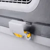 A close-up view of a gray and white pet carrier latch with yellow locking mechanisms. Podgląd zdjęcia produktu