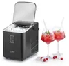 A black ice maker is shown next to two glasses of red cocktails with ice and mint. Several ice cubes and raspberries are scattered on the white surface. Podgląd zdjęcia produktu