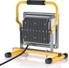 A portable LED work light with a yellow stand and handle, and a gray metal casing with cooling fins. Anteprima dell’immagine prodotto