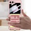 A hand holding a pink flip phone case with a gold accent and a strap with the letters 'FIH' on it. Produktbild-Vorschau