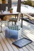 An outdoor setting with a table, chairs, and a storage box on a wooden deck. Produktbild-Vorschau