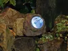 A solar-powered rock light is embedded in a rock garden setting. Anteprima dell’immagine prodotto