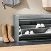 A shoe cabinet with a bench seat and shoes stored inside. Náhled obrázku produktu