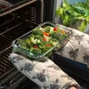 A glass baking dish filled with broccoli and red bell peppers is being removed from an oven. Anteprima dell’immagine prodotto