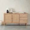 A wooden sideboard with rattan detailing, decorated with a lamp, books, and a vase. Produktbild-Vorschau