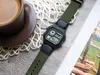 A digital watch is placed next to a cup of coffee on a wooden table. Produktbild-Vorschau