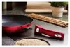 A red frying pan with a detachable handle is shown on a kitchen counter. Produktbild-Vorschau