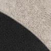 Close-up view of the underside and top of a round rug, showing the backing and the plush texture of the rug. Produktbild-Vorschau