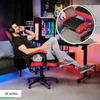 A man is relaxing in a gaming chair in a room with colorful lighting. Produktbild-Vorschau