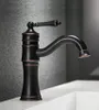 A close-up shot of a vintage-style black faucet with bronze accents, mounted on a white sink. Náhľad obrázku produktu