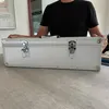 A person is holding a silver aluminum case on a table. Produktbild-Vorschau