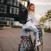 A woman riding a bicycle in an urban setting. Anteprima dell’immagine prodotto