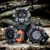 Three G-Shock watches are displayed on a textured wooden surface, suggesting an outdoor or rugged environment. Produktbild-Vorschau