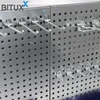 A close-up view of a modular metal pegboard system with hooks attached. Produktbild-Vorschau