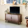 A TV stand with a television and decorative items in a living room setting. Anteprima dell’immagine prodotto
