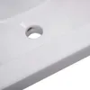 A close-up view of a white ceramic sink with a drain hole. Produktbild-Vorschau