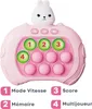 A pink electronic game with a rabbit design on top, featuring buttons and pop-it bubbles, with text labels below. Produktbild-Vorschau