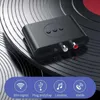 A black Bluetooth audio receiver is placed on a vinyl record. Produktbild-Vorschau