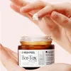 A hand is applying cream from a jar. Náhľad obrázku produktu