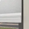 Close-up view of white pleated blinds partially covering a window. Produktbild-Vorschau