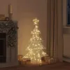 A decorative Christmas tree with warm white LED lights is placed in a cozy room next to a fireplace and curtains, with gift boxes around it. Podgląd zdjęcia produktu