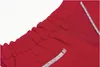A close-up view of the waistband and pocket detail of red shorts. Produktbild-Vorschau