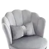 A close-up view of a gray velvet chair with a scalloped back and a decorative pillow. Produktbild-Vorschau